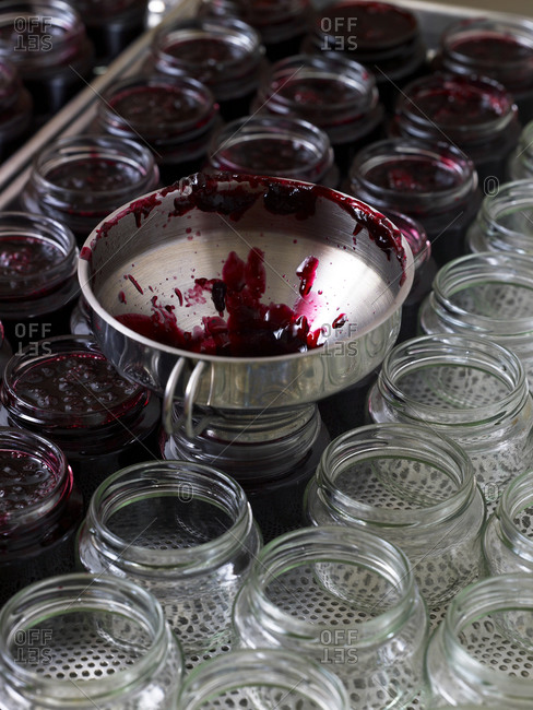 Filling cherry jam into glass jars