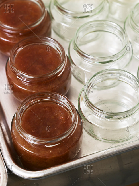 Close up of empty and rhubarb jam-filled jars