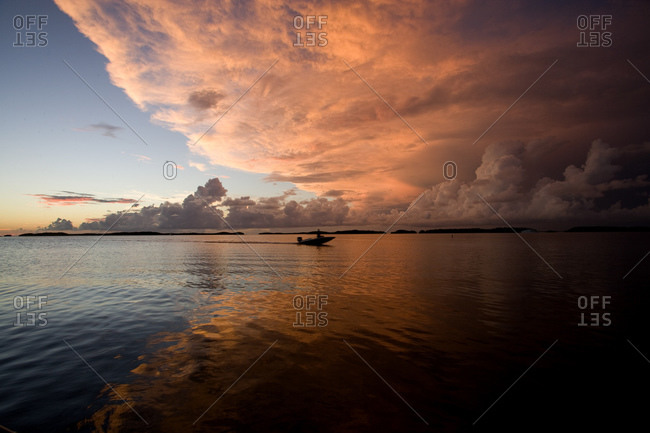 Dramatic seascape with clouds reflection and a single boat