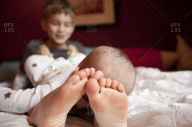 Little boy with newborn baby in the parents bed.