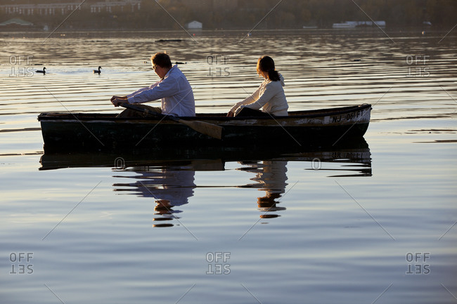 two people row together on a lake