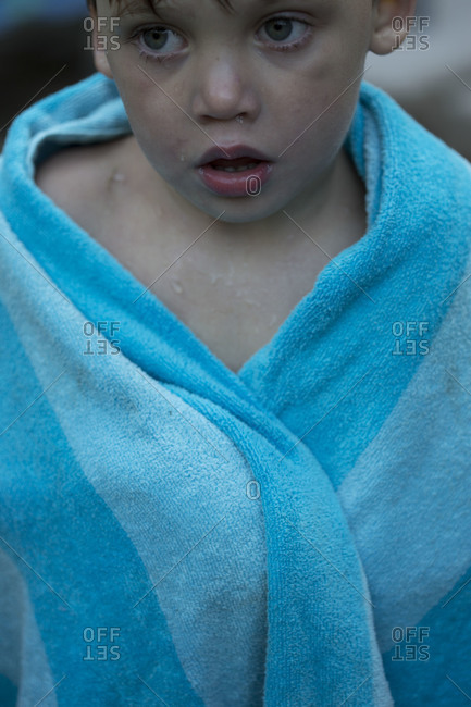 Little wet swimmer boy in towel, portrait