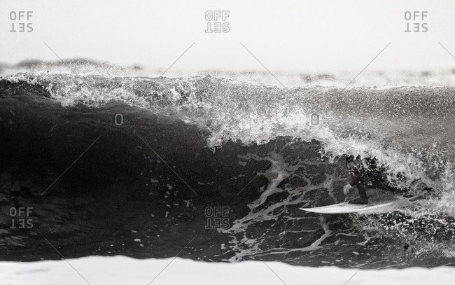 Male surfer moving under wave