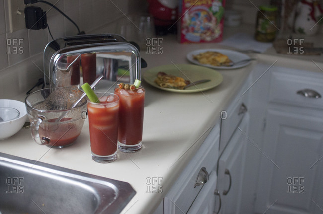 Kitchen counter with dinner and two glass of Bloody Mary cocktails