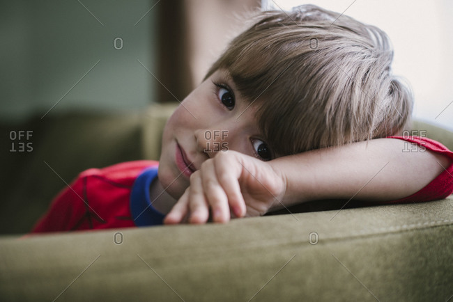 A little boy resting in a living room