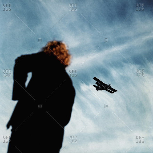 A Person Looking Up In The Sky At An Airplane Stock Photo Offset