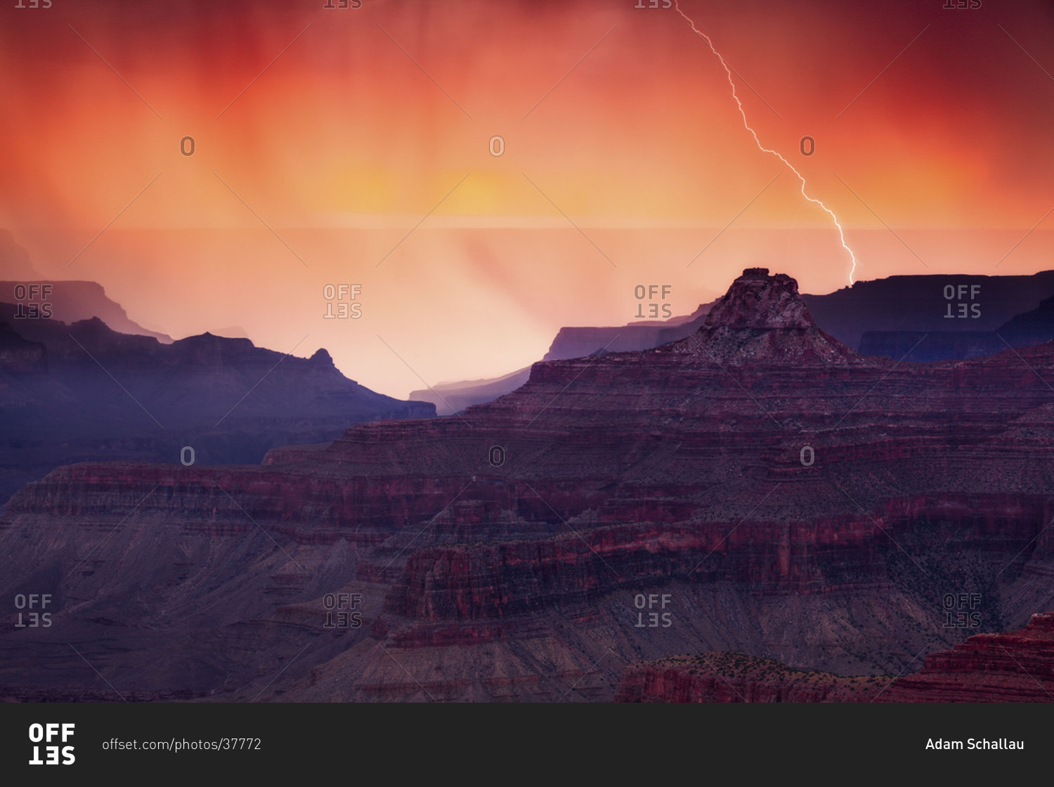 Lightning from a summer monsoon thunderstorm strikes a ridge in the Grand Canyon at sunset