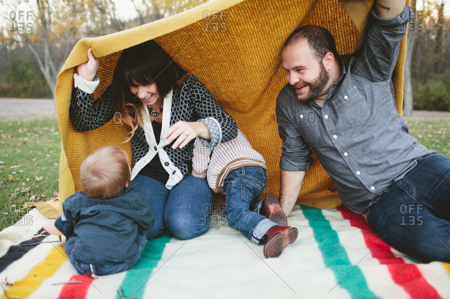 a family plays together on a blanket