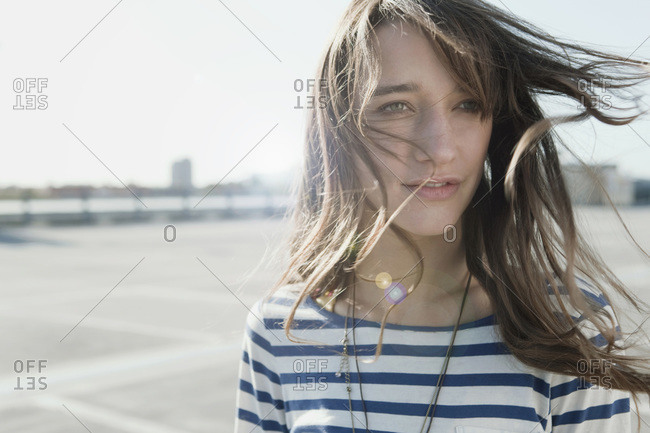 Germany, Berlin, Young woman on deserted parking level, portrait, close-up