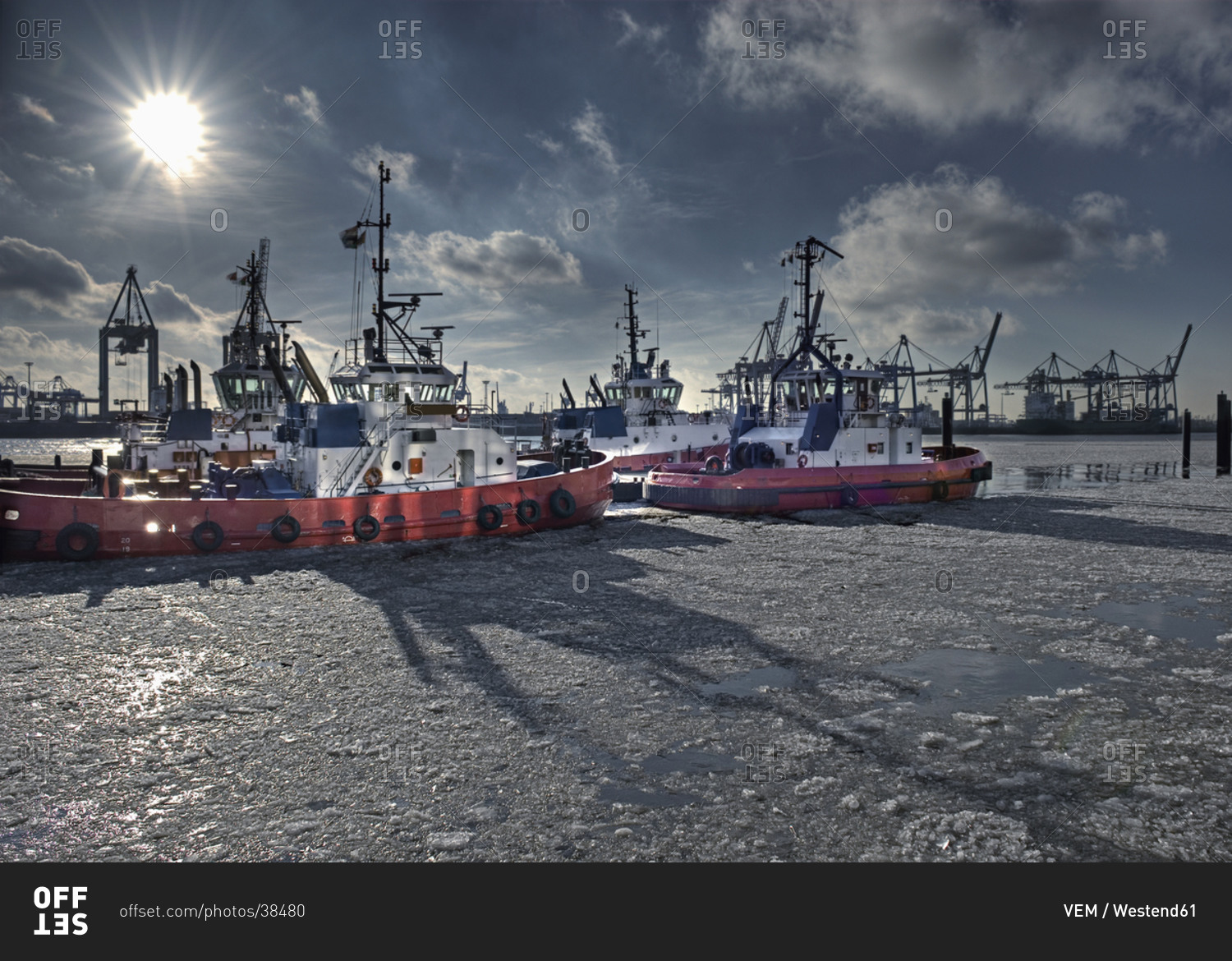 Germany, Hamburg, View of tugs moored at harbour on frozen water