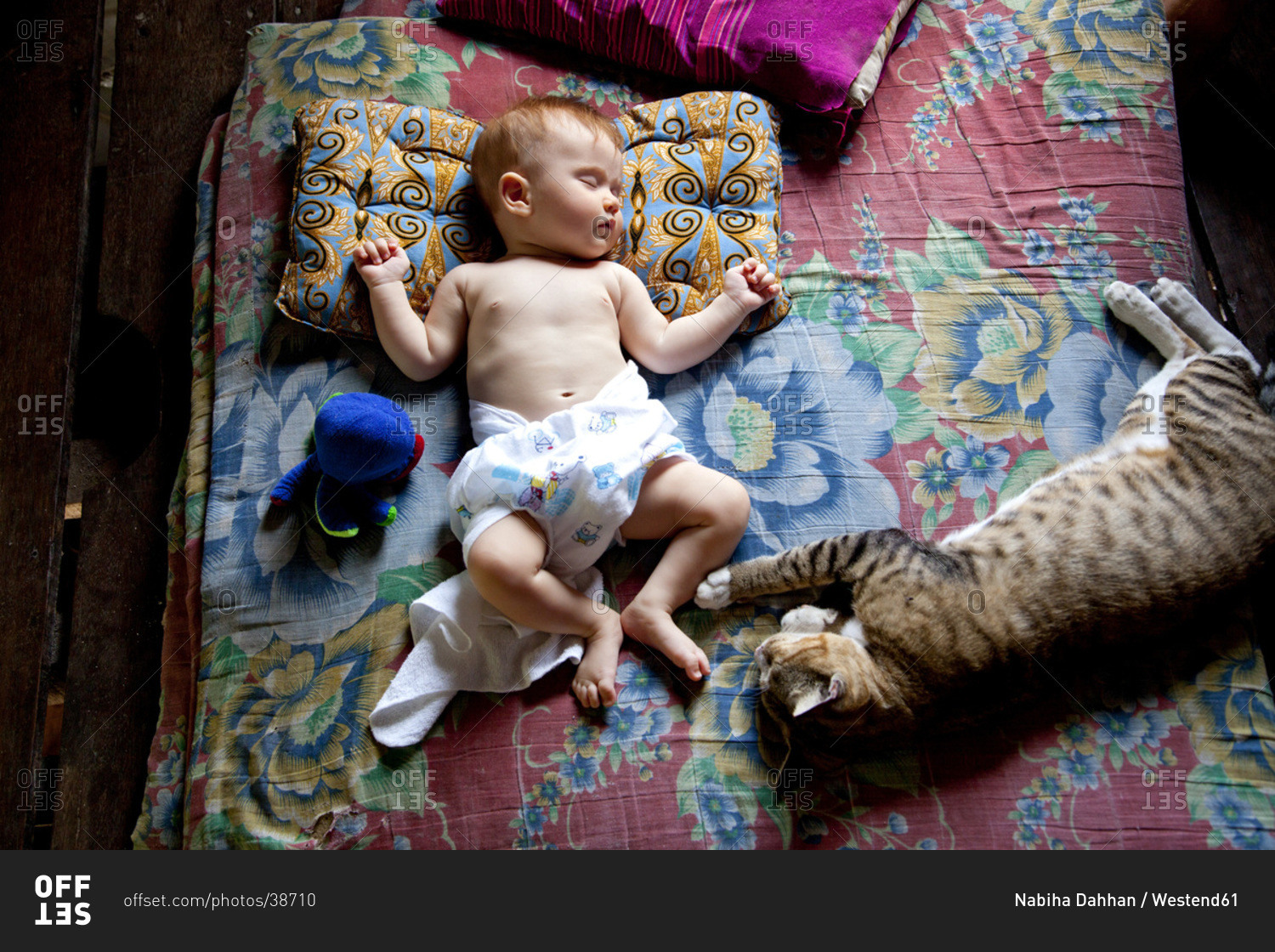 Thailand, Baby and cat sleeping on bed