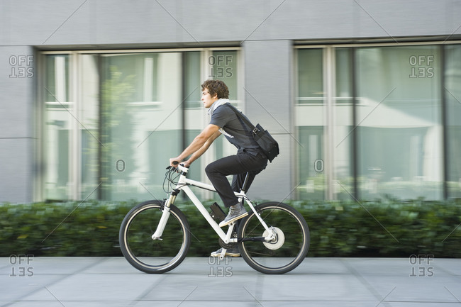 Germany, Bavaria, Young man riding bicycle
