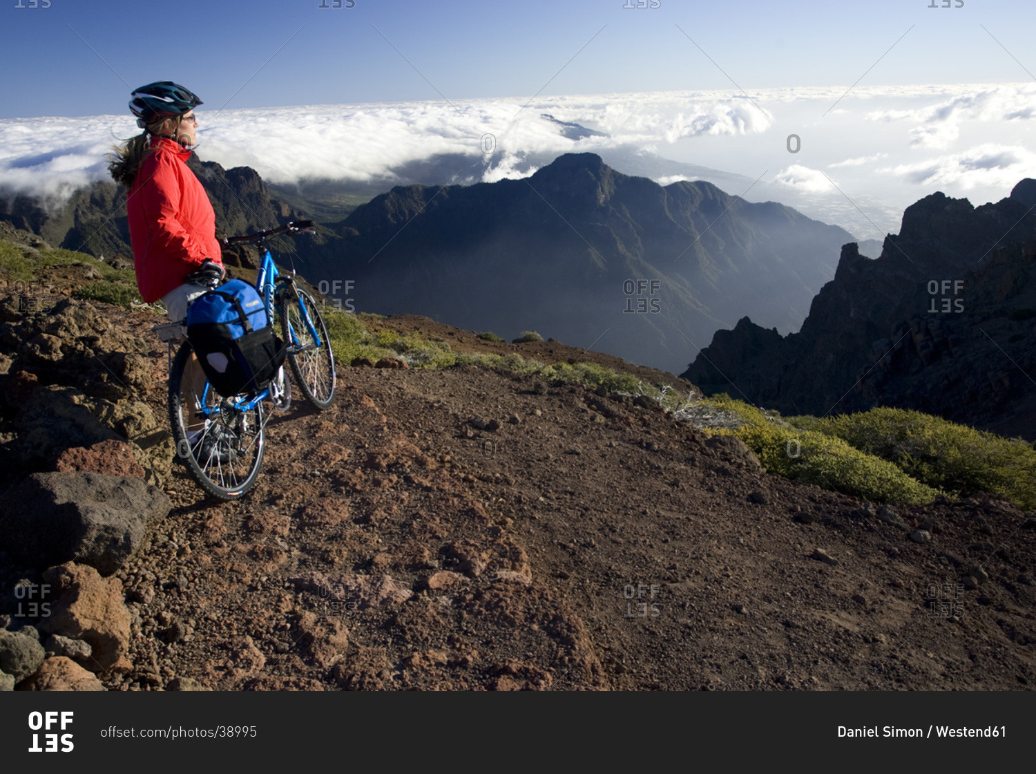 Spain, The Canary Islands, La Palma, Woman with mountain bike looking at mountain scenery