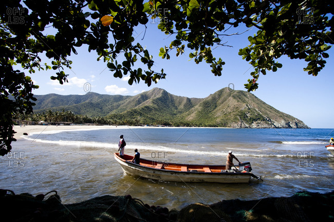 A colorful skiff pulls into the remote village of chuao after an open water crossing from choroni, venezuela