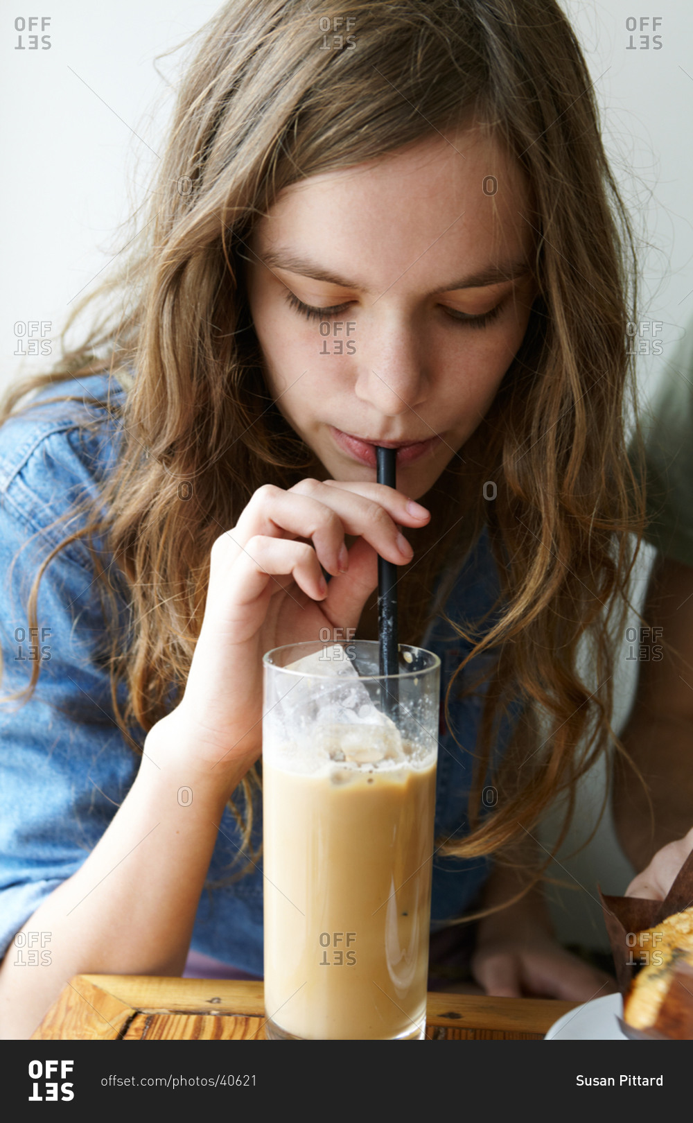 Portrait of girl drinking ice coffee with straw stock photo OFFSET