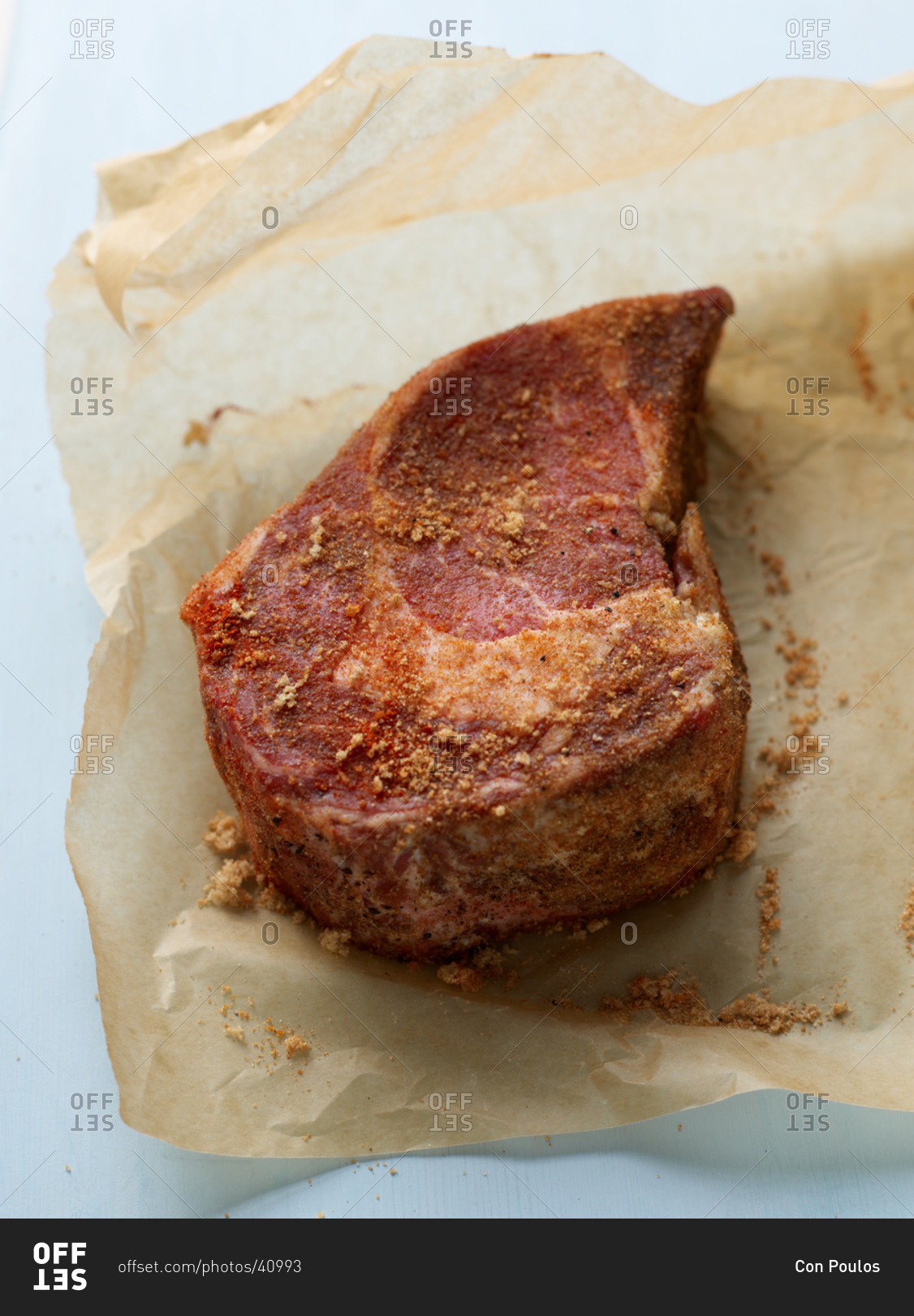 Seasoned raw beef steak on parchment paper