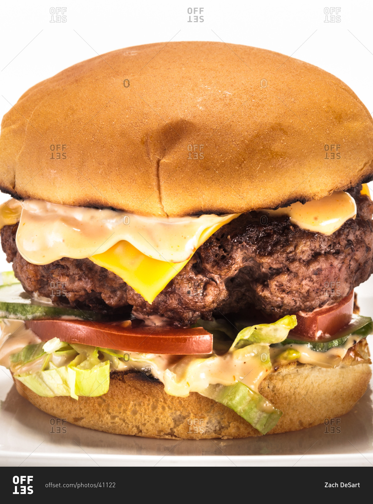 Side view of a rich cheeseburger displayed on white background stock ...