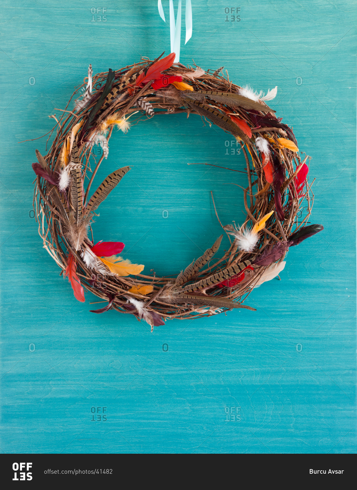 Bird nest wreath hanging over blue surface