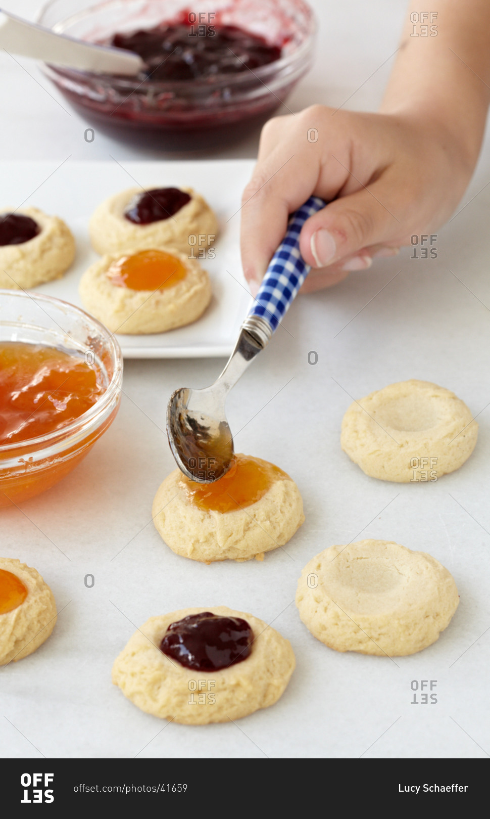 Preparing thumbprint cookies with various jam types at home