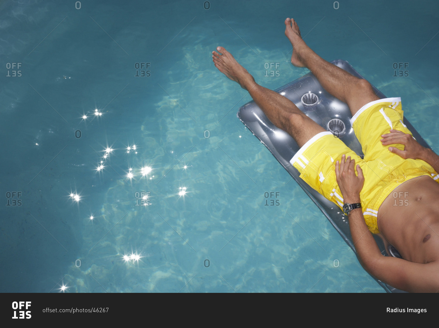 Man floating in pool stock photo OFFSET
