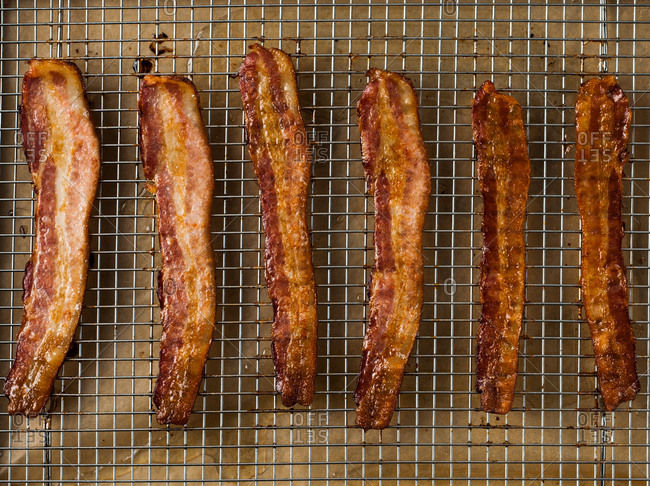 Fried bacon cooling on a rack.