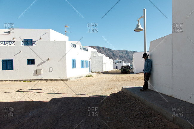 Man leaning against wall in Caleta Del Sebo, Canary Islands, Spain