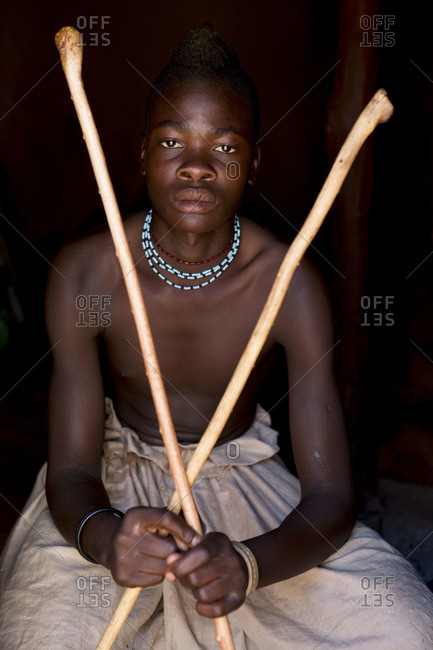 Portrait of young Himba man holding sticks