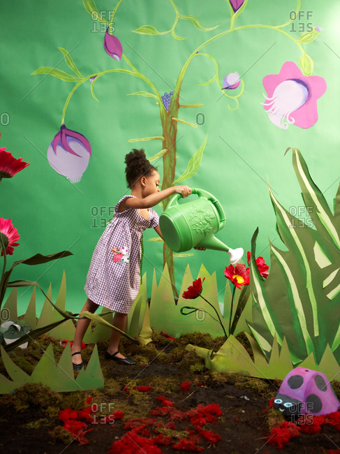 Young  girl imitating gardening in studio