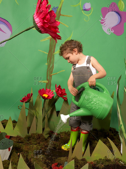 Young boy imitating gardening in studio