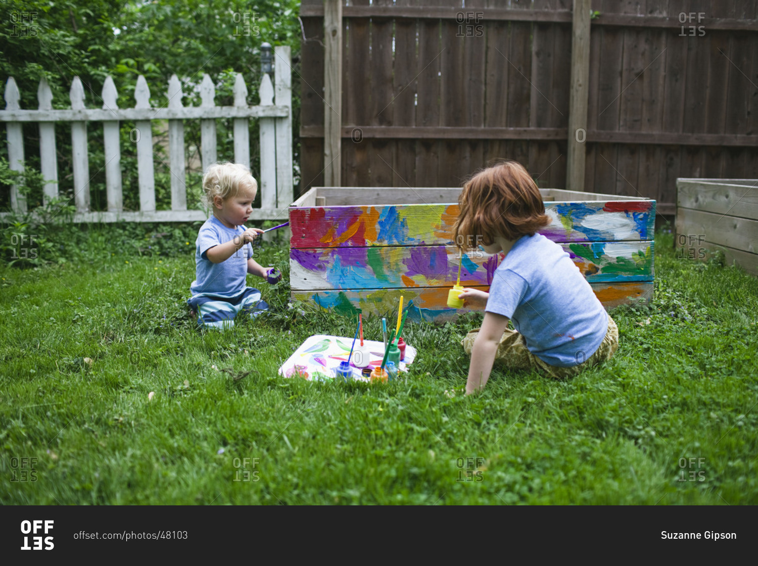 Two children paint a sandbox