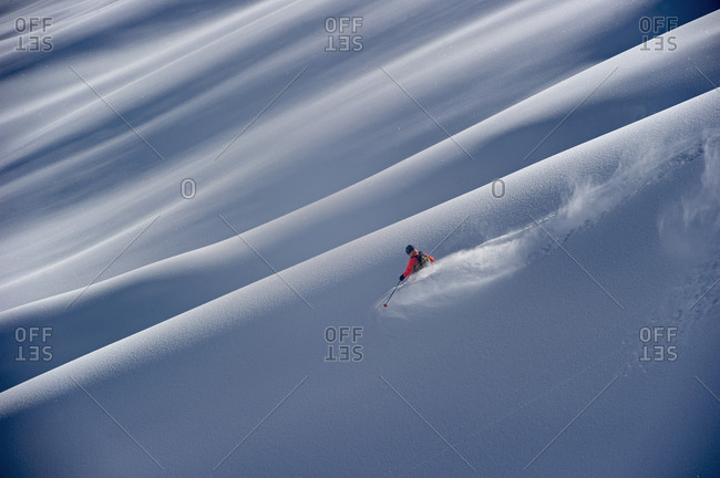 A ski guide rides on sun shadow lines.