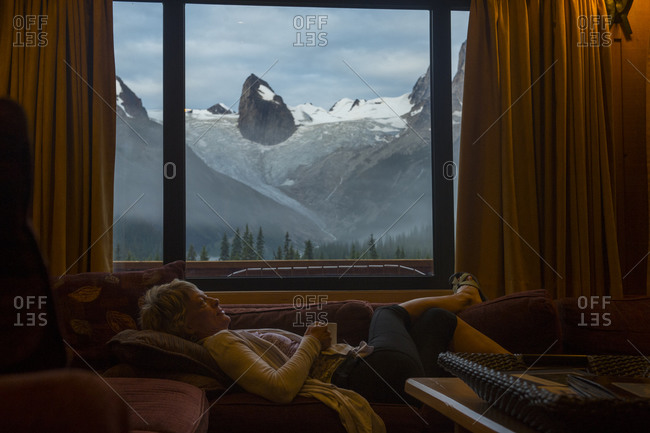 Woman relaxes and enjoys a coffee in a remote lodge.