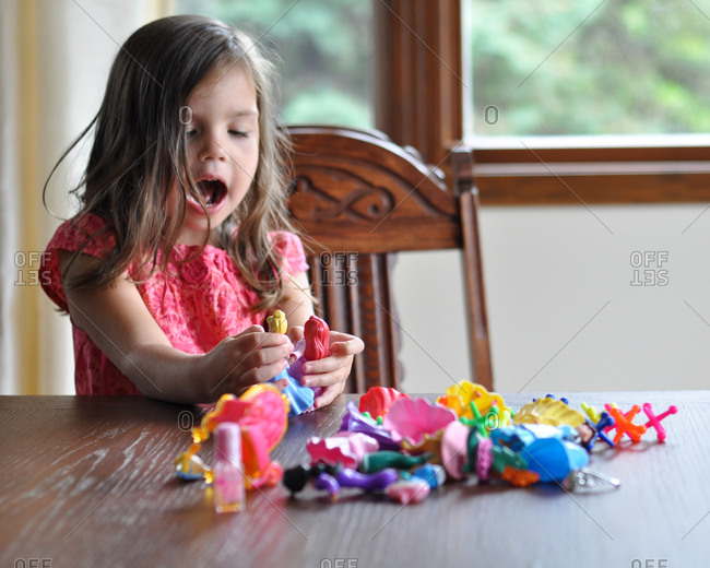 A little girl plays with plastic figurines