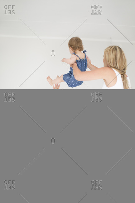 Parents and little daughter playing in bedroom