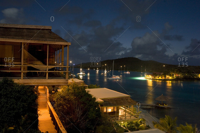 Night view of beachfront cottages and tranquil yachting location.
