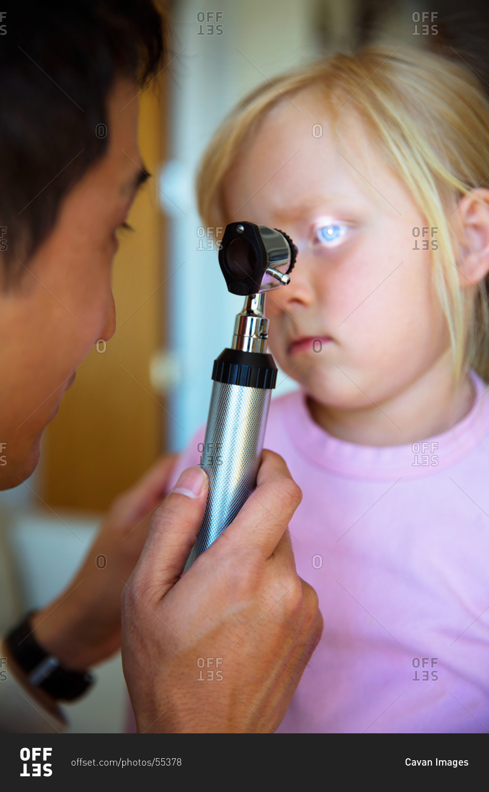 Doctor Exams Eyes with Ophthalmoscope stock photo OFFSET