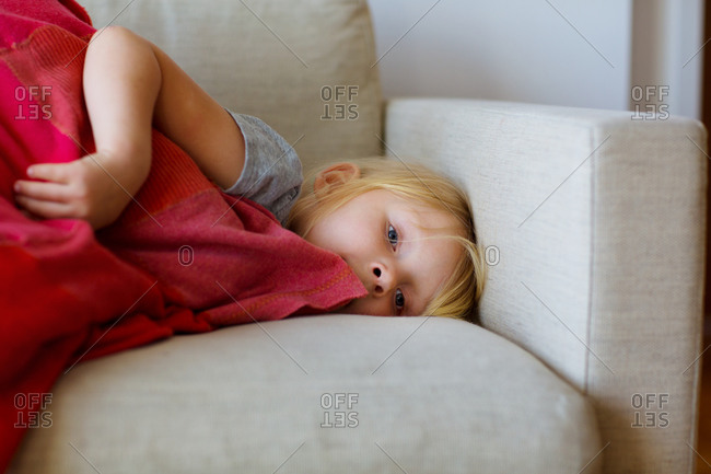 Girl lying on couch with blanket