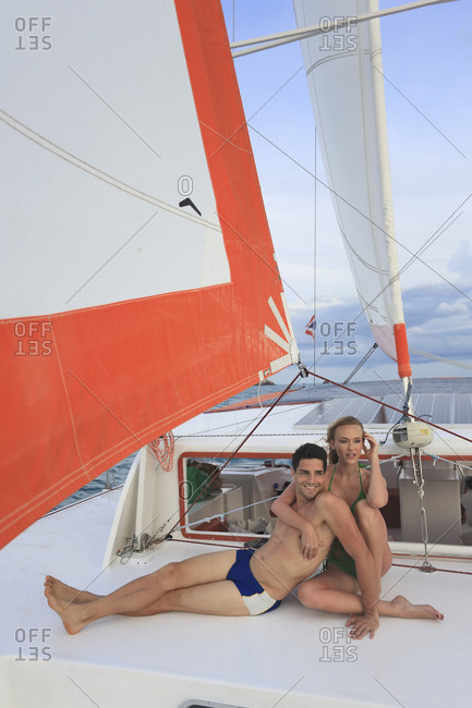 High angle view of couple sitting on deck of sail boat