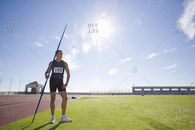 Male athlete with pole, low angle view (lens flare)