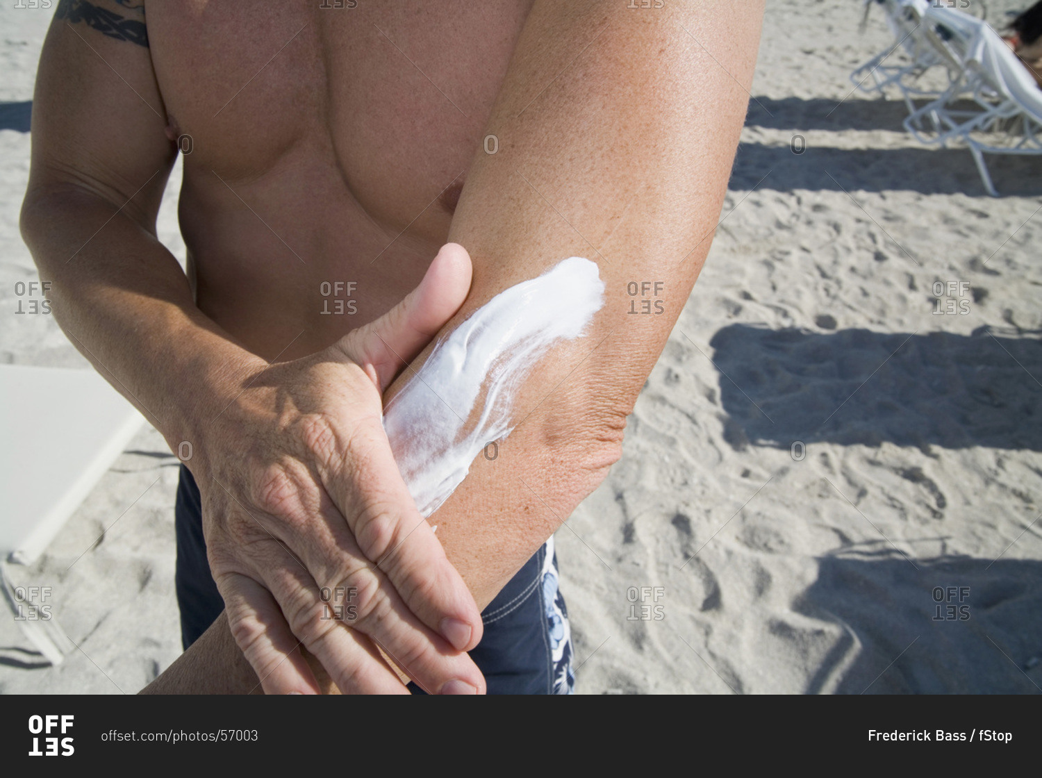 Man applying sunscreen to arm