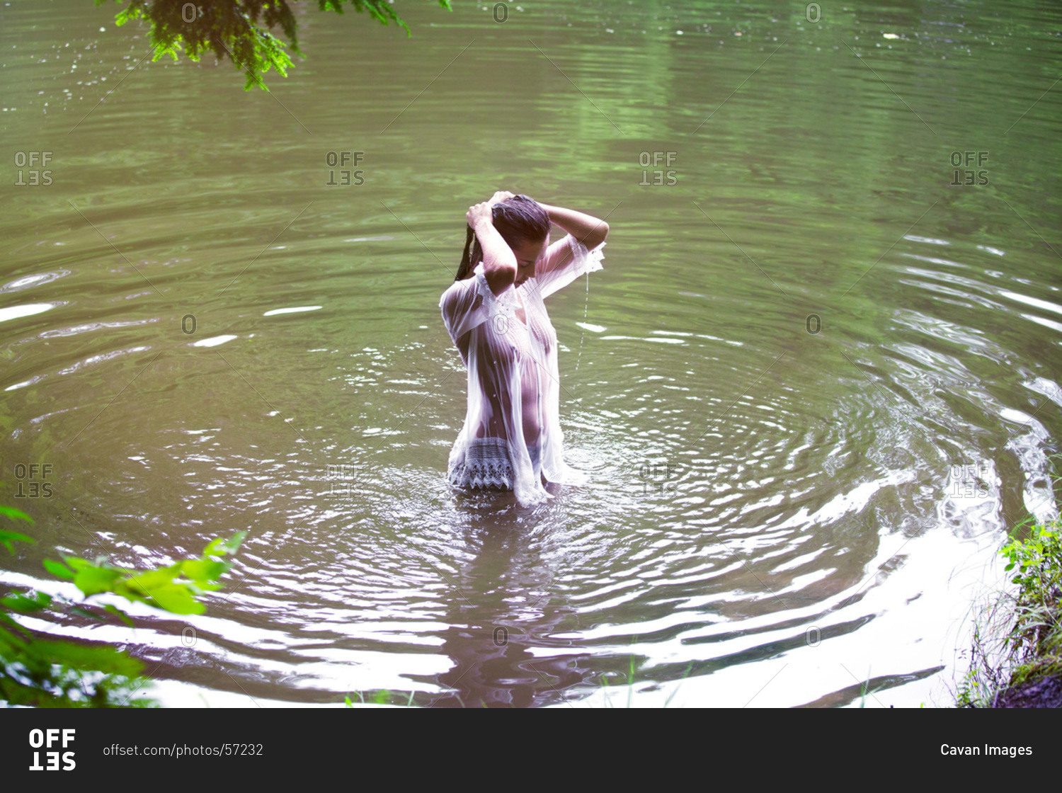 Girl in a white wet blouse in lake water