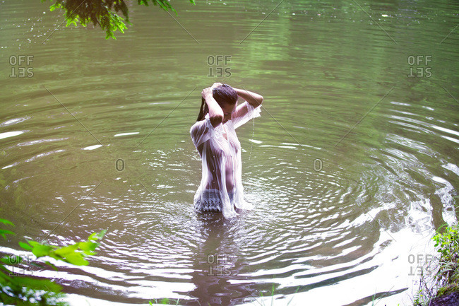 Girl in a white wet blouse in lake water