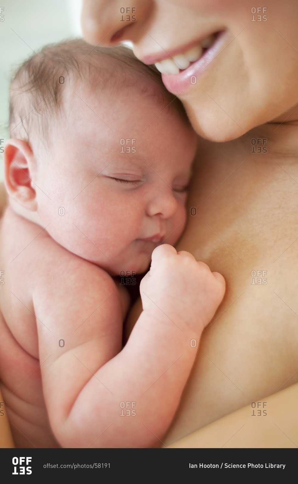 Newborn baby held by her mother.