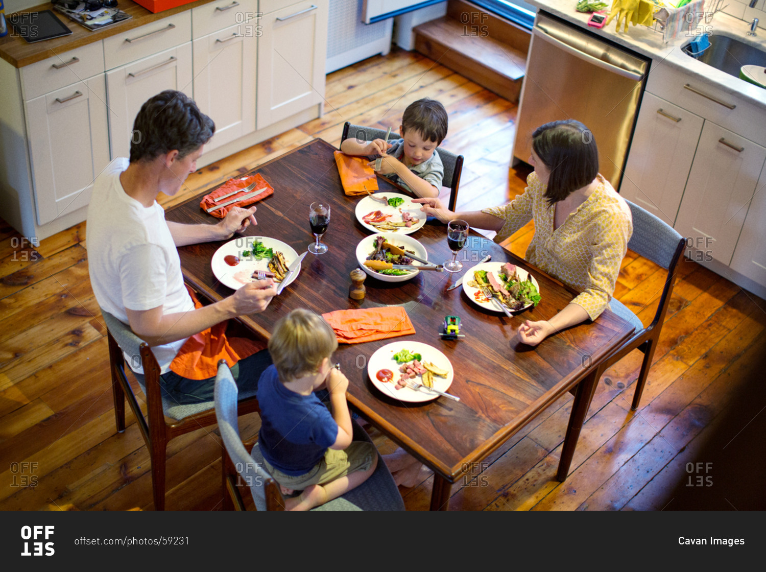 Overhead view of family eating dinner in kitchen