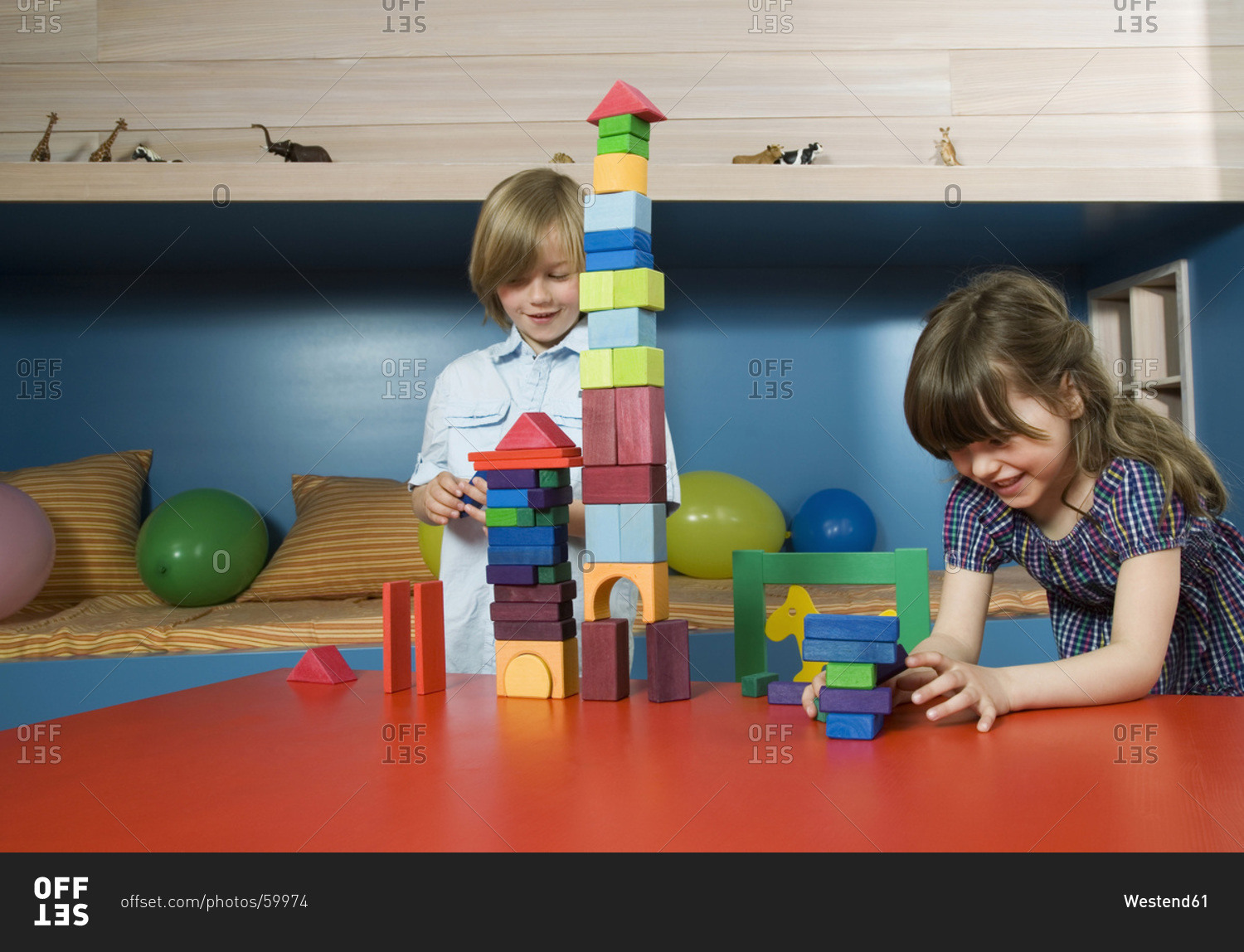 Boy (8-9) and girl (6-7) playing building bricks, portrait