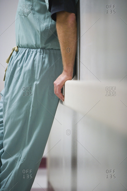 Doctor in scrubs leaning