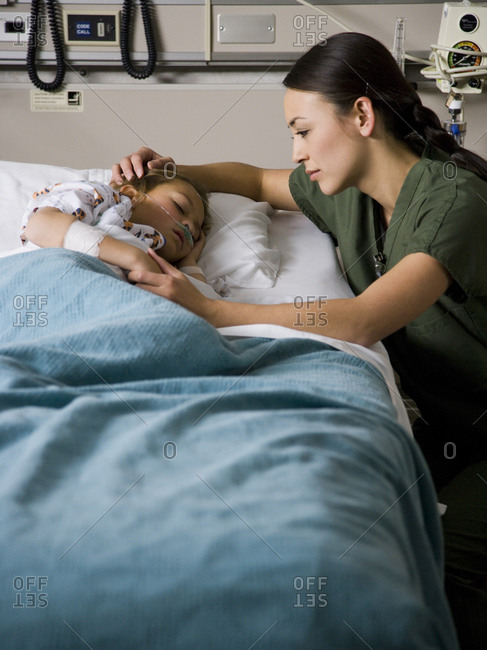 Young girl in hospital bed with nurse