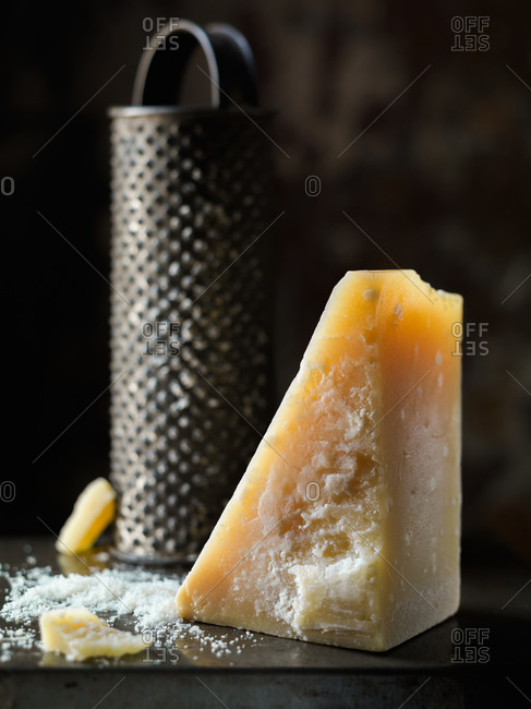 Block of parmesan cheese with vintage grater