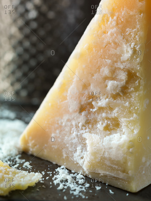 Block of parmesan cheese with vintage grater