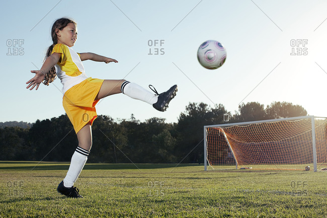 A young girl playing soccer on a soccer field in Los Angeles, California